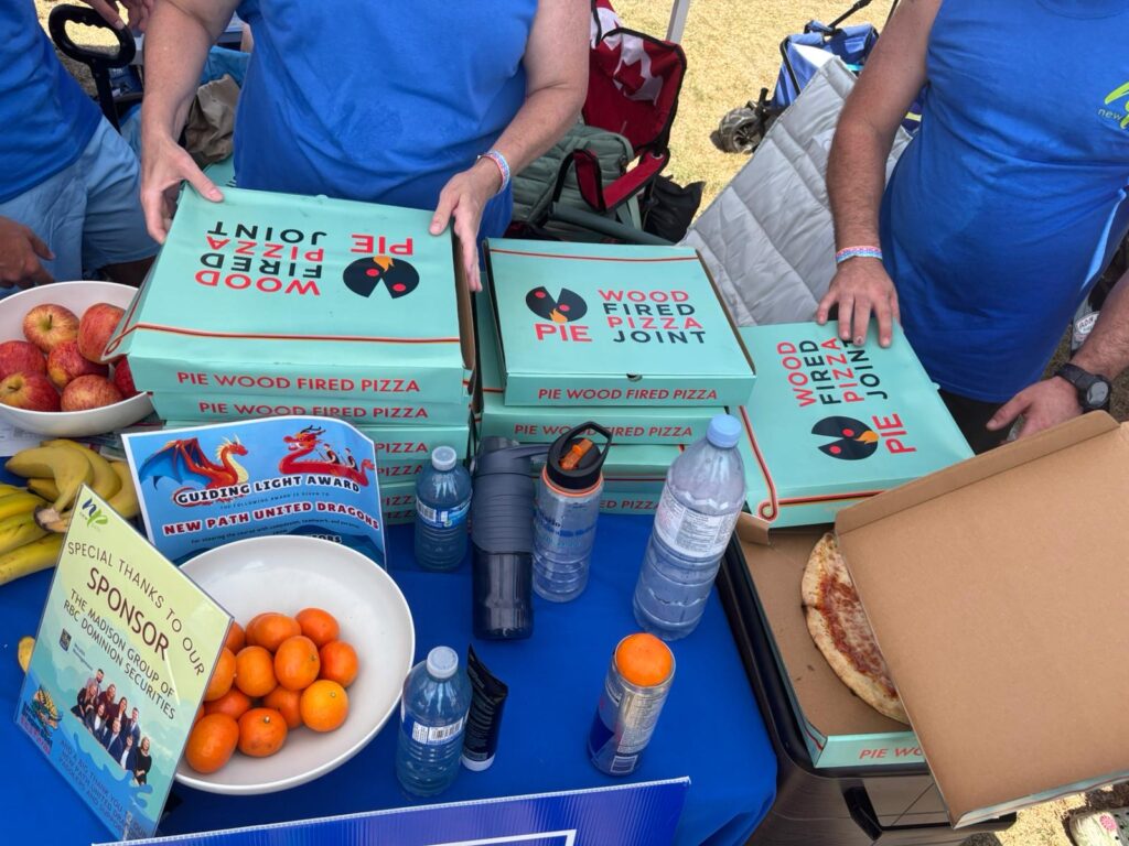 Picture of a table with pizza boxes and other food and drinks.