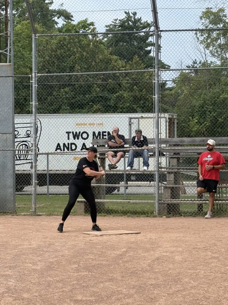 A woman batting in a baseball diamond.