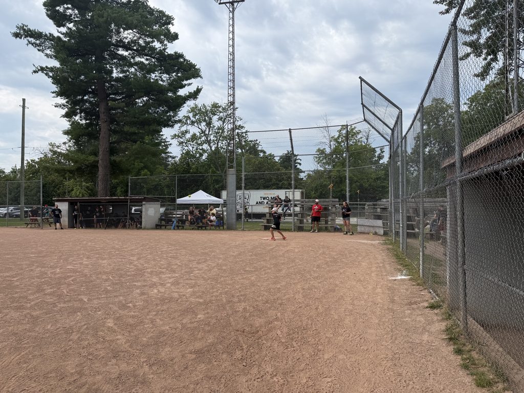 A boy batting in a baseball diamond. 