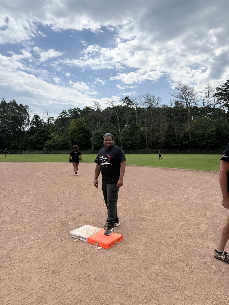 A man standing at first base smiling. 