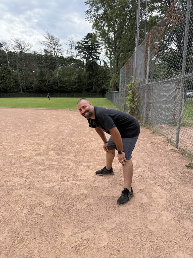 A man bending over smiling. 