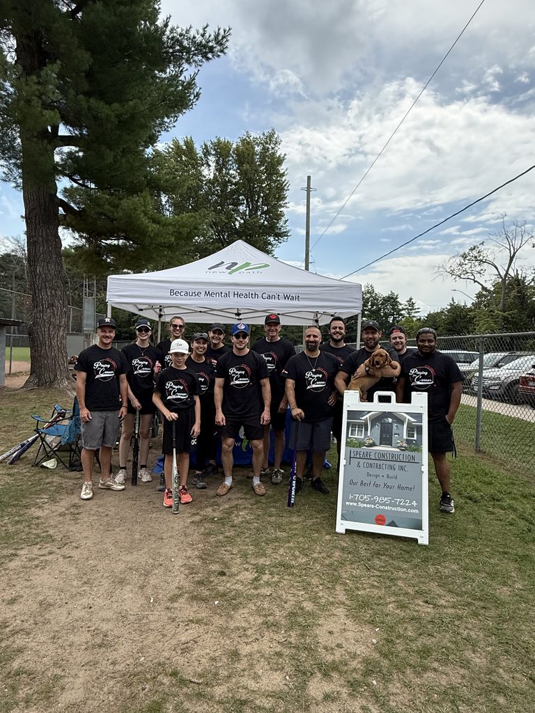 Picture of a group of people in front of a Rick Speare's Construction Sign and in front of a New Path tent that says Because Mental Health Can't Wait