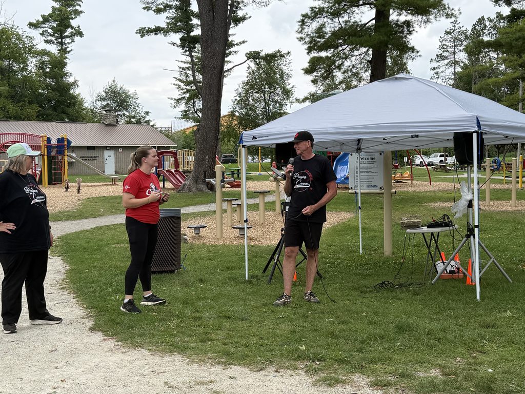 A person holding a microphone talking to people. 