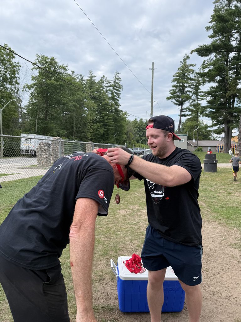 A man putting a medal over the nexk of another man