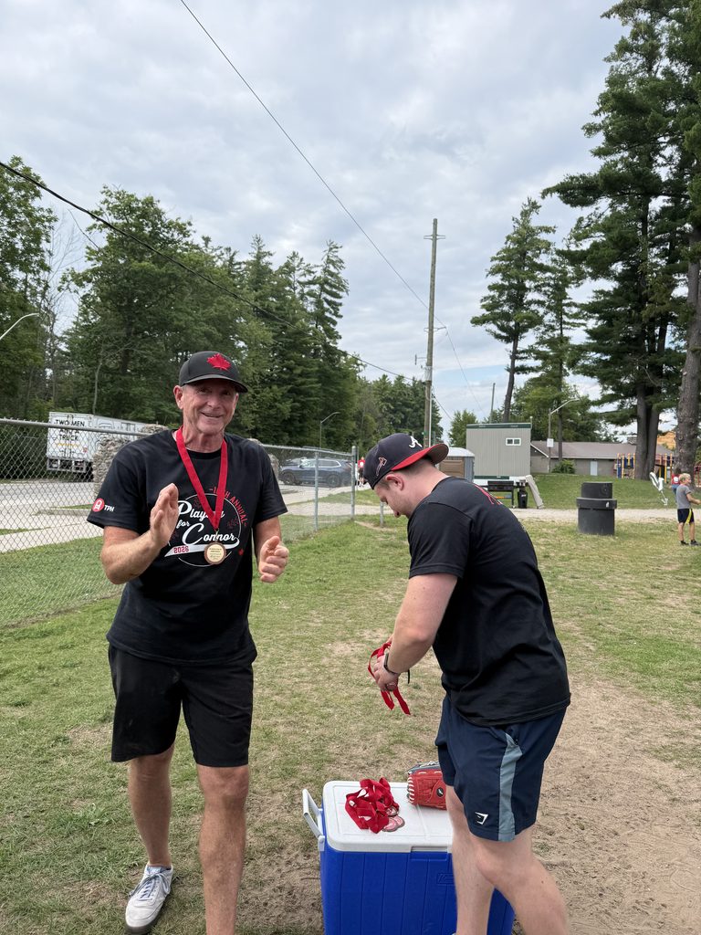 Two men holding medals. 