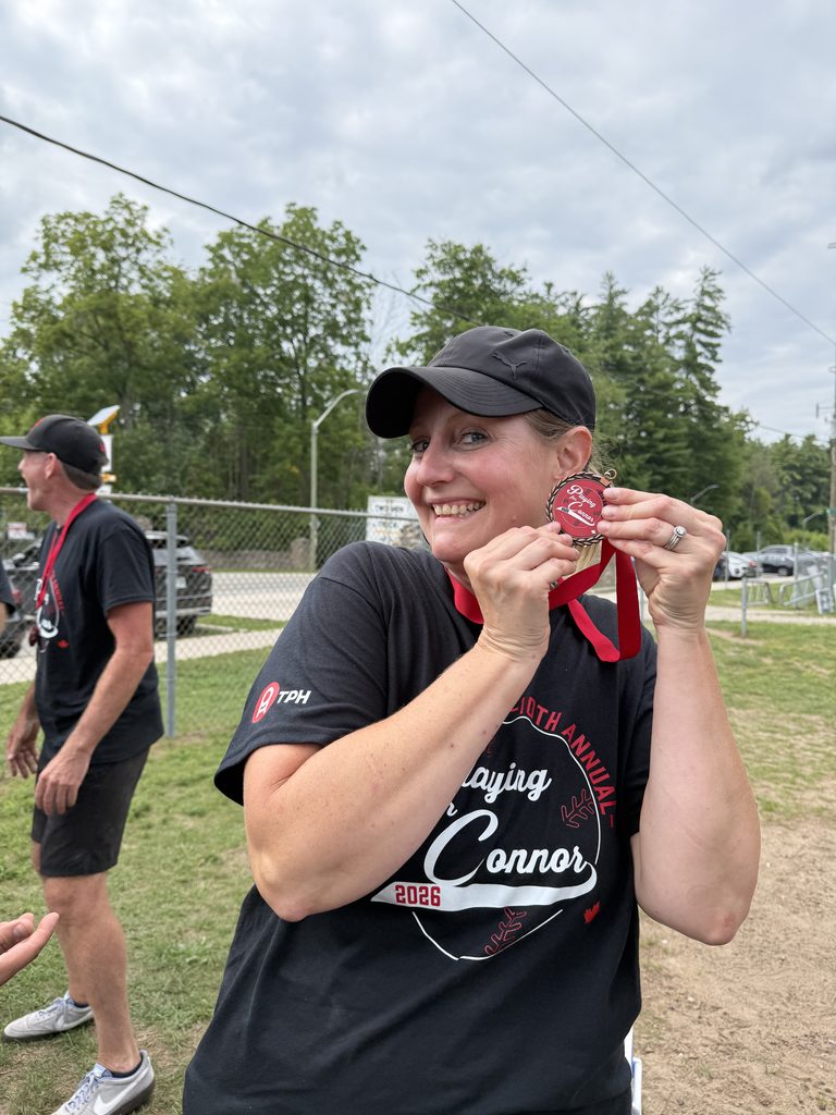 A woman holding a medal and smiling