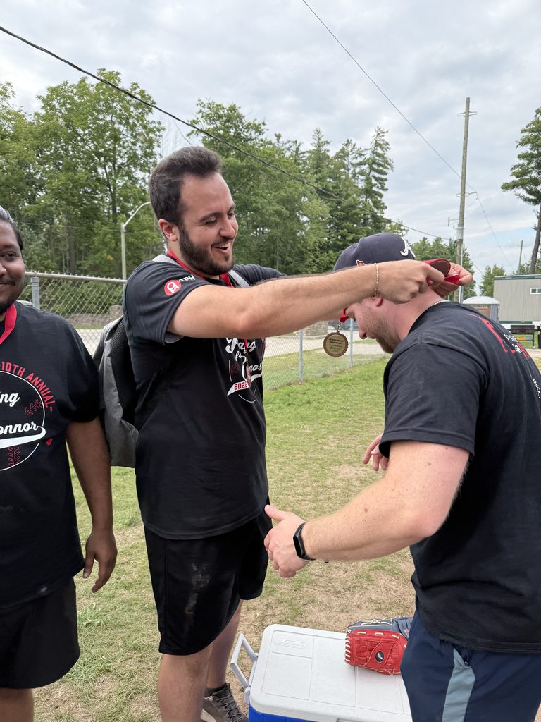A man putting a medal over the neck of another man. 