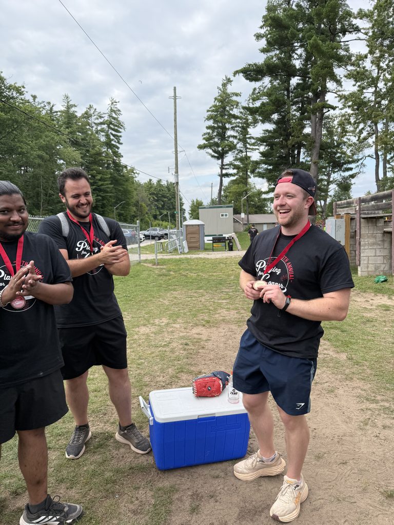 Three men wearing medals laughing.