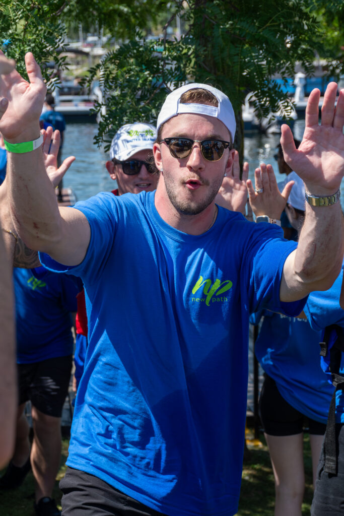 Picture of a man smiling and giving high fives to other people