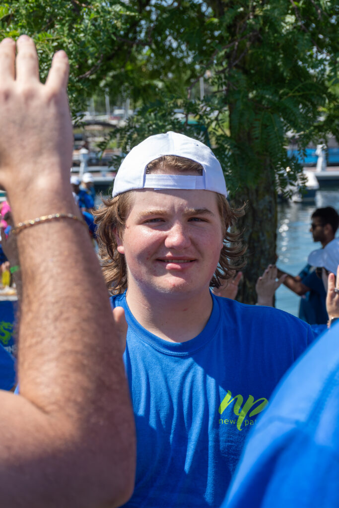 Picture of a man smiling and giving high fives to other people