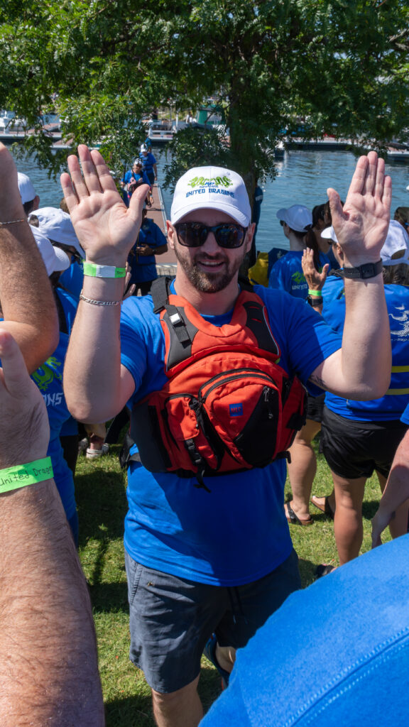 Picture of a man smiling and giving high fives to other people