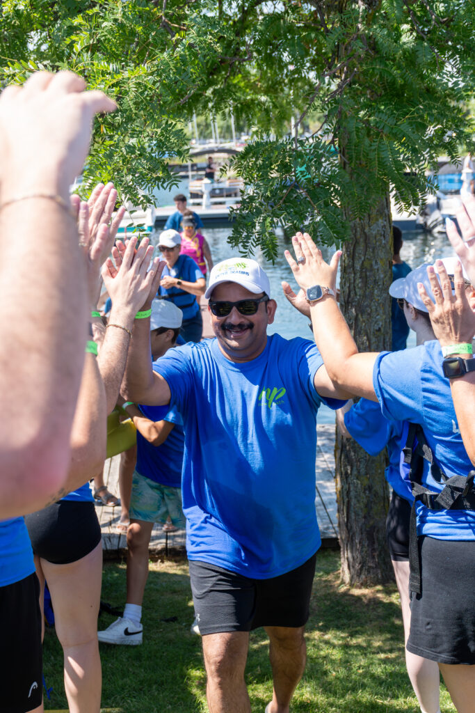 Picture of a man smiling and giving high fives to other people