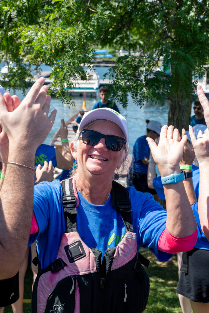 Picture of a woman smiling and giving high fives to other people