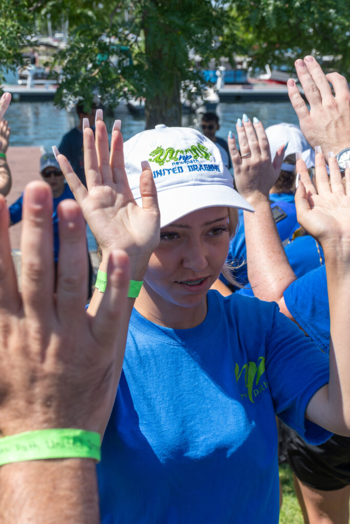 Picture of a woman smiling and giving high fives to other people
