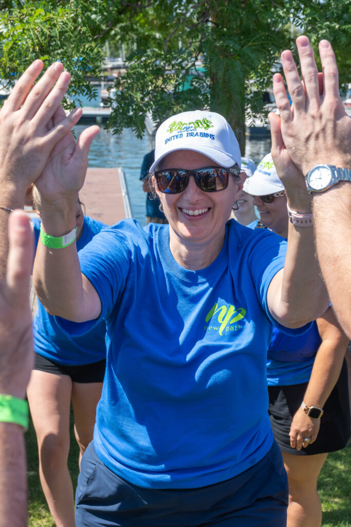 Picture of a woman smiling and giving high fives to other people