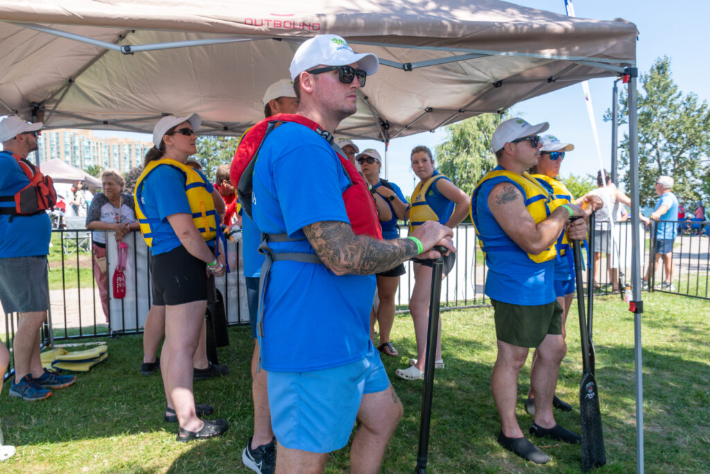 A group of people wearing life jackets and holding paddles