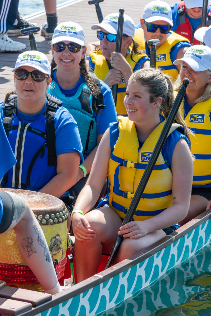 a group of people in a dragon boat smiling