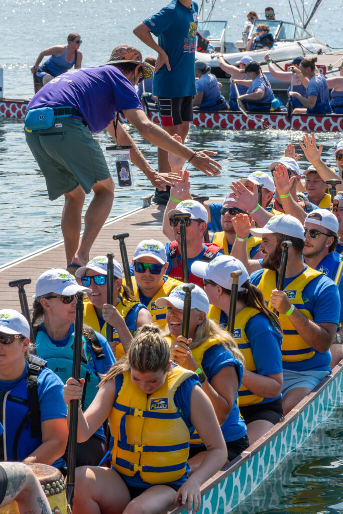 a group of people in a dragon boat smiling