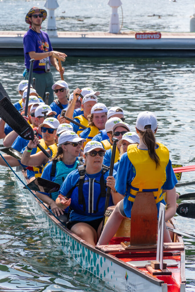 a group of people in a dragon boat smiling