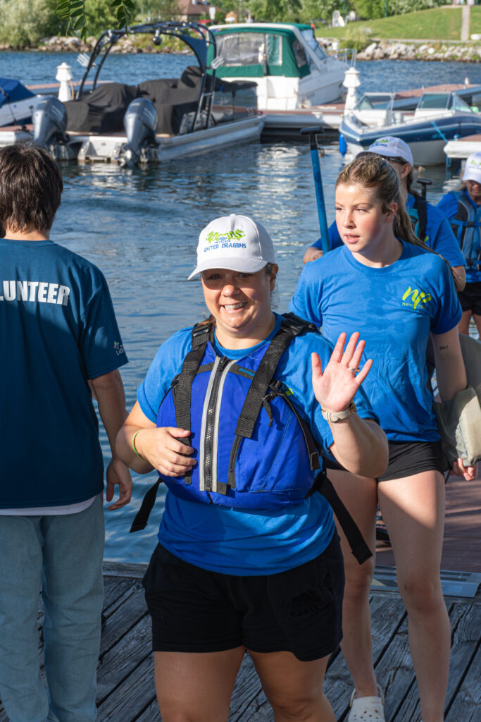 Picture of a woman smiling and giving high fives to other people