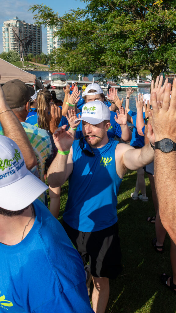 Picture of a group of people smiling and giving high fives to other people