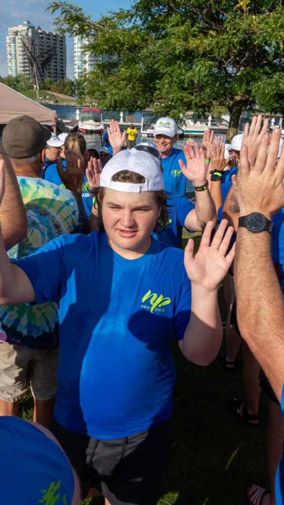 Picture of a man smiling and giving high fives to other people