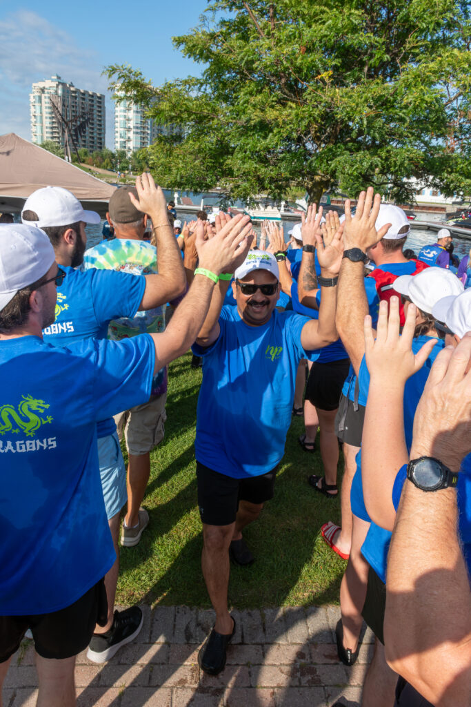 Picture of a group of people smiling and giving high fives to other people