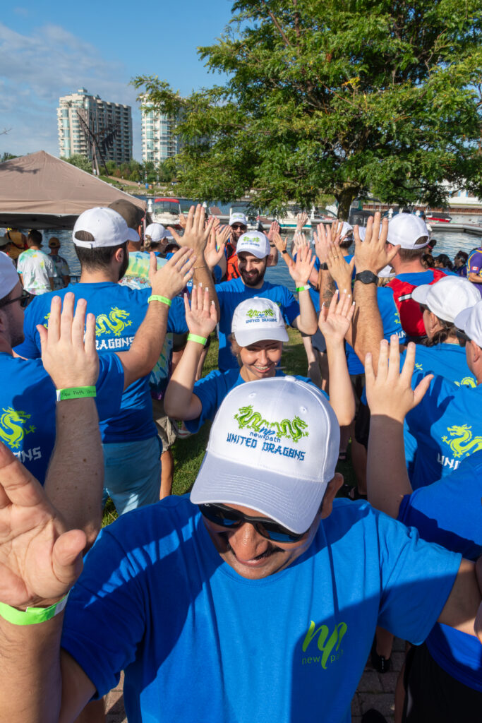 Picture of a group of people smiling and giving high fives to other people