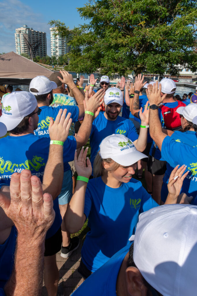 Picture of a group of people smiling and giving high fives to other people