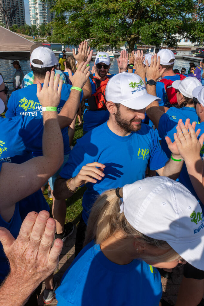 Picture of a group of people smiling and giving high fives to other people
