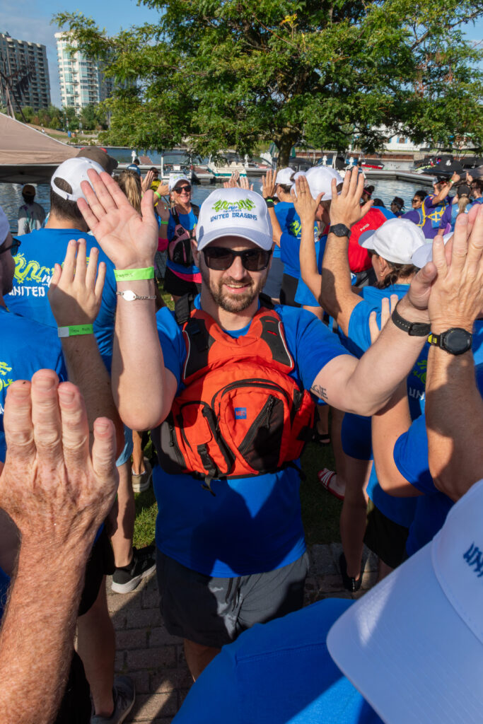 Picture of a group of people smiling and giving high fives to other people