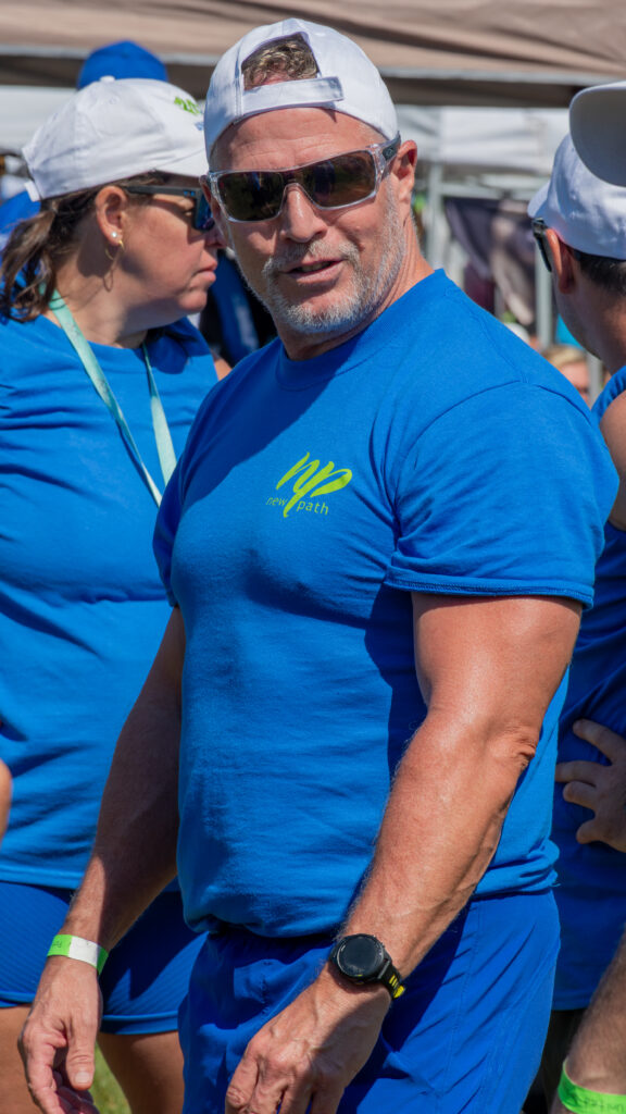 Picture of a man wearing a New Path United Dragon hat and t-shirt smiling