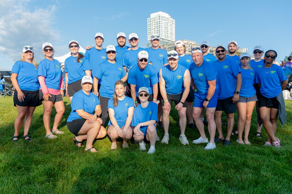 Picture of a group of people smiling with buildings in the background
