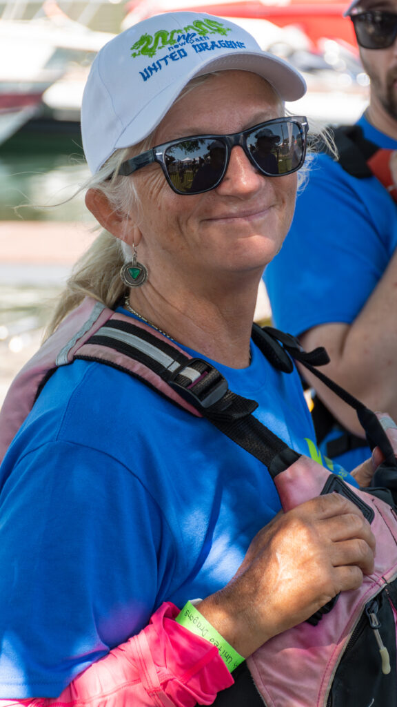 Picture of a womman wearing a New Path United Dragon hat and t-shirt smiling