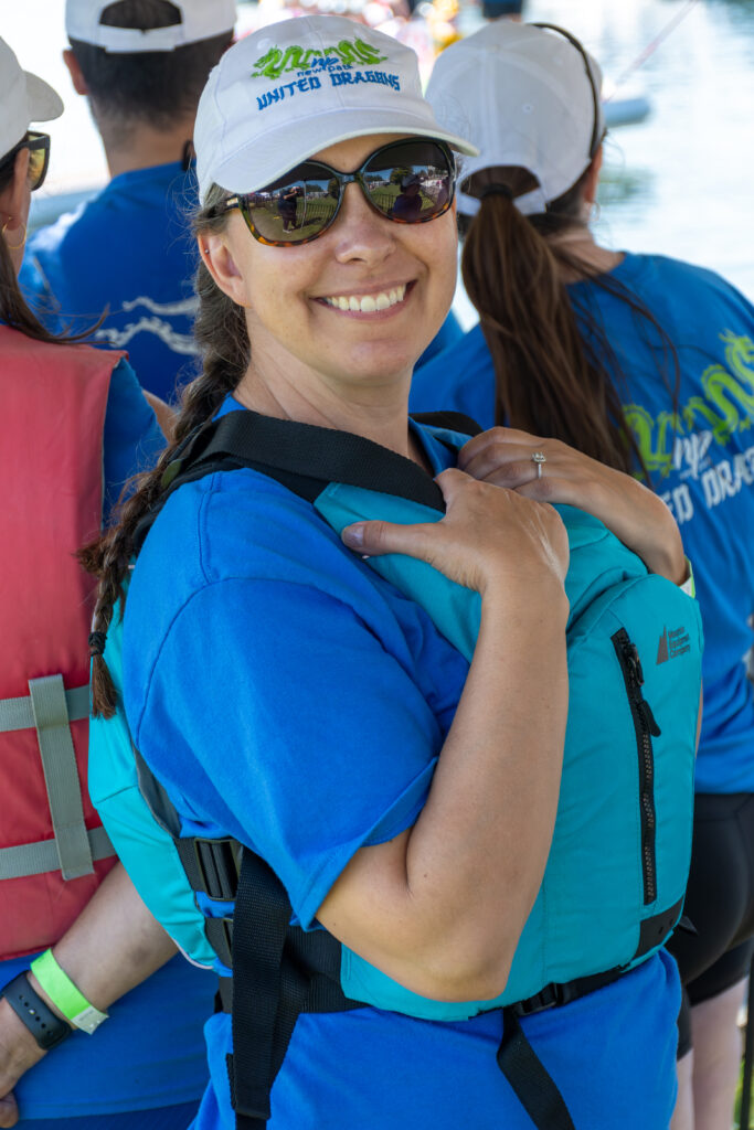 Picture of a woman wearing a New Path United Dragon hat and t-shirt smiling