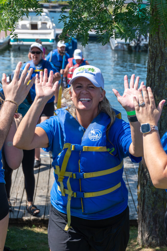 Picture of a woman smiling and giving high fives to other people
