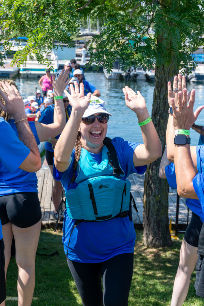Picture of a woman smiling and giving high fives to other people