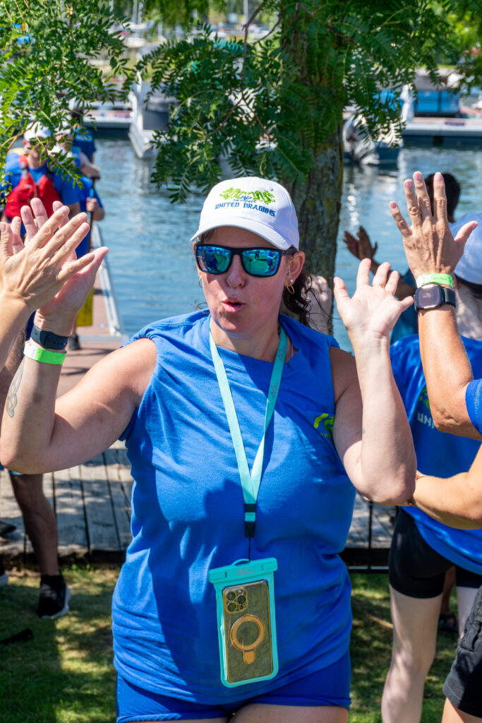 Picture of a woman smiling and giving high fives to other people