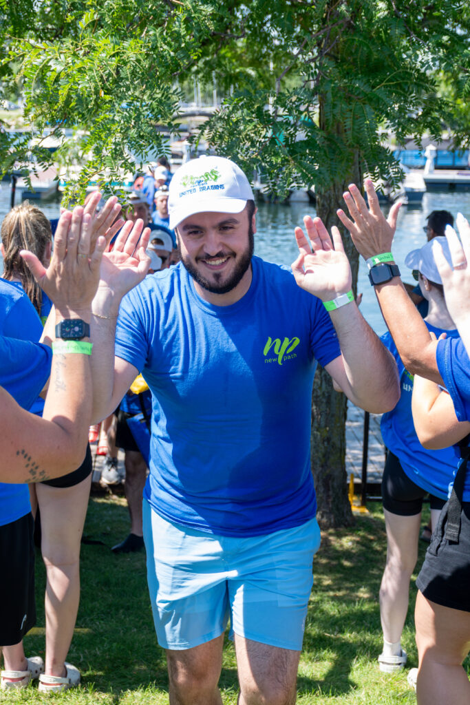 Picture of a man smiling and giving high fives to other people
