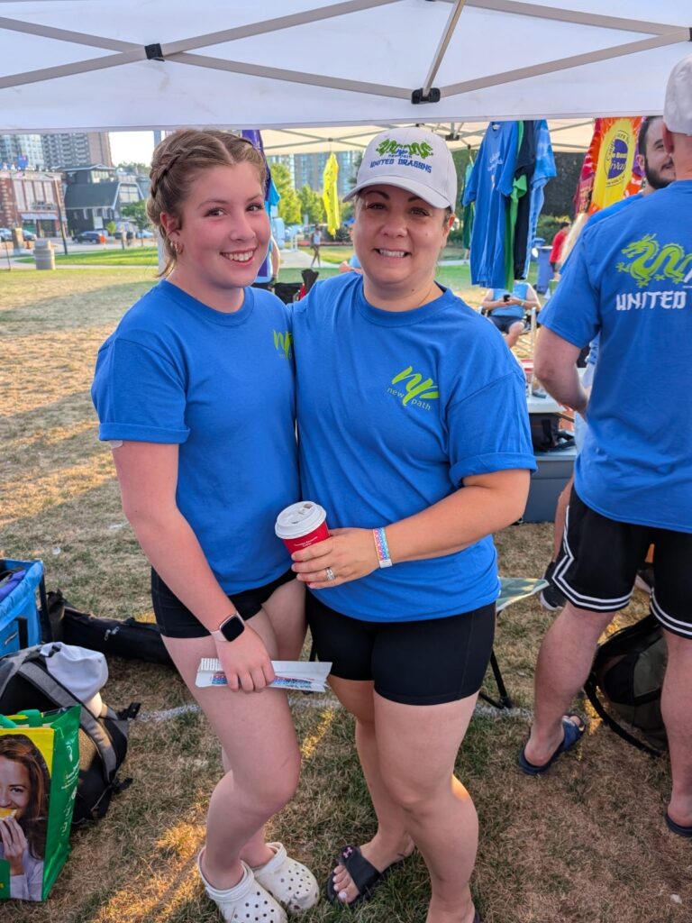 Picture of two women smiling under a tent.